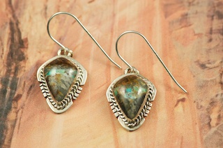 Genuine Sunnyside Turquoise set in Sterling Silver French Wire Earrings. The matrix on this rare stone is outstanding. The Sunnyside mine is located in northern Nevada near the town of Tuscarora in the Tuscarora mountain range. The mine is no longer in operation as it has become part of a gold mining operation and a privately owned ranch. The Sunnyside mine was mined mostly in the 70's. You won't find much of this great turquoise around anymore except for old stashes. Created by Navajo Artist Arkie Nelson. Signed by the artist.